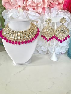 the necklace and earrings are on display in front of pink hydranges with white flowers