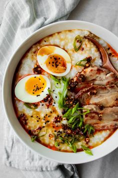 a bowl filled with rice, meat and boiled eggs