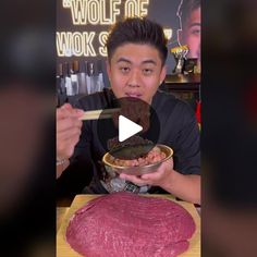 a man holding a bowl filled with meat in front of a large piece of meat