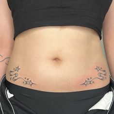 a woman's stomach with tattoos on it