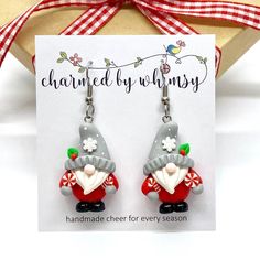 a pair of earrings with an image of a gnome on it and the words charmed by whimsyy