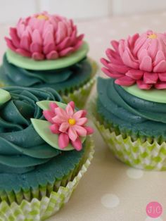 three cupcakes decorated with green frosting and pink flowers