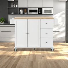 a kitchen with white cabinets and an island on wheels in front of the countertop