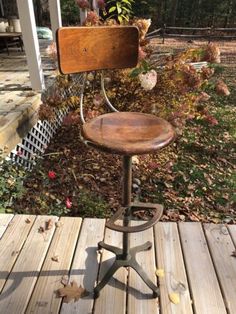 an old stool sitting on top of a wooden deck