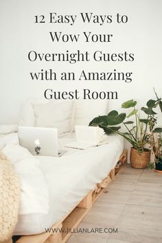 a white bed sitting next to a plant on top of a hard wood floor in front of a white wall