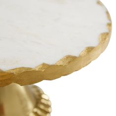 a white marble topped table with gold accents