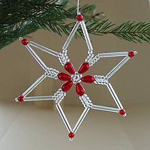 a christmas ornament hanging from a tree with red and white beads on it