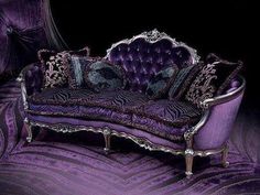 a purple couch sitting in front of a black background