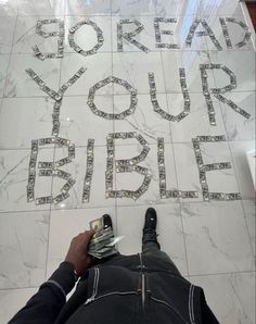 someone is laying on the floor with money in front of them and writing that reads, pray your bible