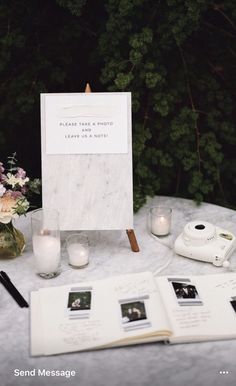 an open book sitting on top of a table next to some candles and other items