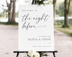 a welcome sign for the night before at an outdoor wedding ceremony with white flowers and greenery