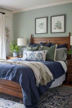 a bedroom with blue and white bedding, two pictures on the wall above the bed