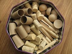 a tin filled with lots of different types of wooden utensils on top of a table