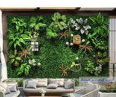 an outdoor living room with plants on the wall and couches in front of it