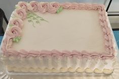 a white cake with pink frosting roses on it