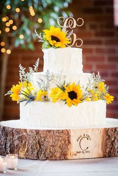 a white wedding cake with sunflowers on top