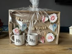 two coffee mugs sitting on top of a wooden table next to a sign that says mr and mrs