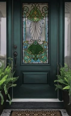 a green front door with potted plants on the side and a stained glass window