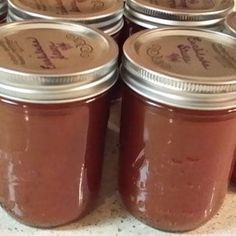 several jars filled with red liquid sitting on top of a counter