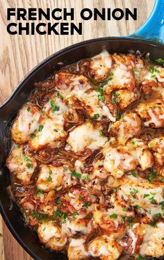 a skillet filled with chicken covered in melted cheese and parsley on top of a wooden table