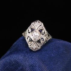 Gorgeous Antique Art Deco 18K White Gold Diamond and Sapphire Shield Ring. This beautiful art deco shield ring features amazing old european cut diamonds and sapphires on a filigree white gold art deco ring. Item #R0622Metal: 18K White GoldDiamond: Approximately .30 ctsColor: HClarity: SI1Weight: 3.1 GramsRing Size: 3Measurements: 16.9 mm wideLayaway: For your convenience, we will be happy to provide layaway payment options. Please contact us to work out a layaway plan which best suits your need Gold Art Deco Ring, White Gold Art, Emerald Ring Engagement Diamond, Wedding Band Engraving, Shield Ring, Diamond Cluster Engagement Ring, Art Deco Diamond Rings, Antique Diamond Rings, Art Deco Glass