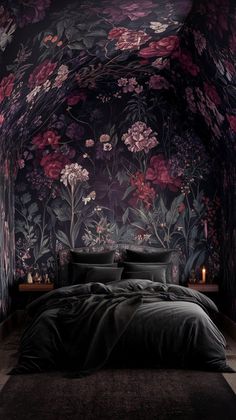 a bedroom with floral wallpaper and dark colored bedding, along with two candles