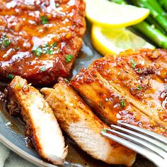 grilled pork chops, asparagus and lemon wedges on a plate