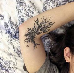 a woman laying on top of a bed covered in tattoos