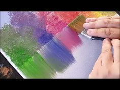 someone using a brush to paint different colored trees