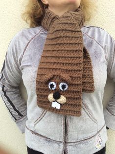 a woman wearing a knitted scarf with a bear on it