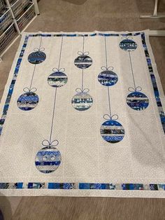 a quilted christmas ornament is hanging on the floor in front of a bookcase