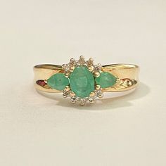 Gorgeous modern 1980s 10k yellow gold emerald ring! This beautiful 1980s ring features a oval cut faceted emerald stone in the center, and surrounding two pear cut emeralds the center gemstone is studded metal work and four genuine diamonds. A stunning piece of fine modern jewelry, featuring May's birthstone! ERA - Circa 1980s METAL / MATERIAL - 10k yellow gold, center oval emerald (approx. .35 CT), 2 pear cut emeralds (approx. .42 ctw) 8 diamonds (approx. .24 ctw) MARKINGS / HISTORY - Inside of Green Oval Diamond Ring Collectible, Vintage Green Marquise Emerald Ring, Vintage Marquise Cut Emerald Ring For Anniversary, Vintage Oval Emerald Cluster Ring, Gold Emerald Ring, Emerald And Diamond Ring, Emerald Ring Gold, Eyes Open, Diamond Ring Settings