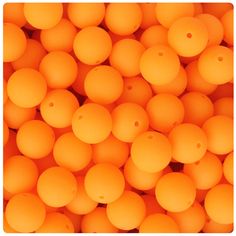 many orange balls are stacked together in a pile