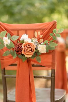 an orange chair decorated with flowers and greenery for a wedding or special event,