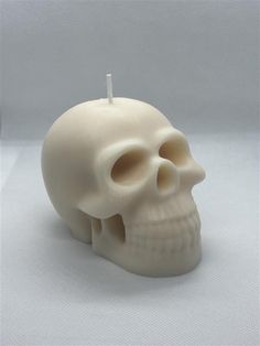 a white candle with a skull on it