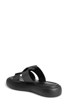 Oversized leather straps kick off a modern slide sandal set atop lightweight padding and a chunky contrast sole. 1 1/2" platform Flat sole Cushioned footbed Leather upper and lining/synthetic sole Imported Modern Double Strap Slides With Cushioned Footbed, Modern Black Footbed Sandals With Textured Footbed, Modern Slides With Double Strap And Removable Insole, Modern Slides With Removable Insole And Double Strap, Modern Black Double Strap Footbed Sandals, Modern Double Strap Synthetic Slides, Modern Slides With Leather Footbed, Modern Black Leather Footbed Sandals, Beach Double Strap Platform Slides