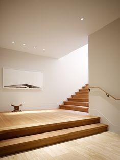 a room with some stairs and a painting on the wall above it in an empty space