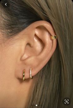 a close up of a person's ear with two rings on it