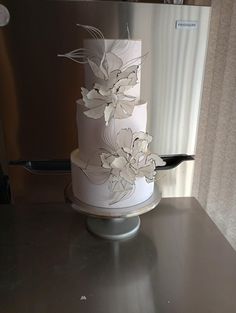 a three tiered cake with white flowers on it