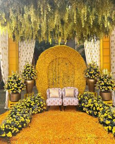 a couch sitting under a yellow flower covered arch