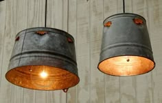 two metal buckets with lights hanging from them