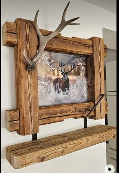 a deer head mounted to the side of a wooden frame with antlers on it