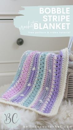 a crocheted blanket sitting on top of a white chair next to a basket