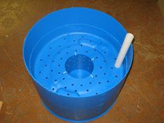 a blue plastic bucket with a toothbrush in it