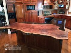 a kitchen island made out of wood in the middle of a hardwood flooring area