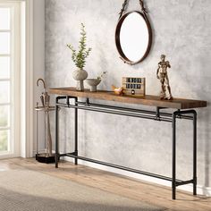 a console table with an oval mirror above it