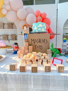 a table topped with lots of cakes and toys