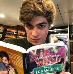 a young man reading a book about los angeles