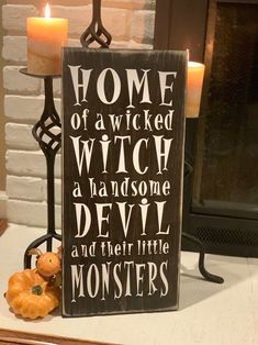 a wooden sign that reads home of a witch, a handsome devil and their little monsters