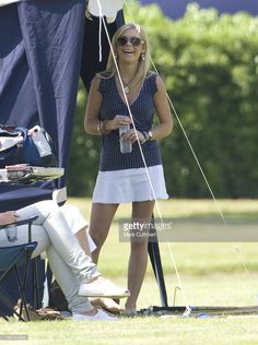 a woman standing next to a tent holding a drink